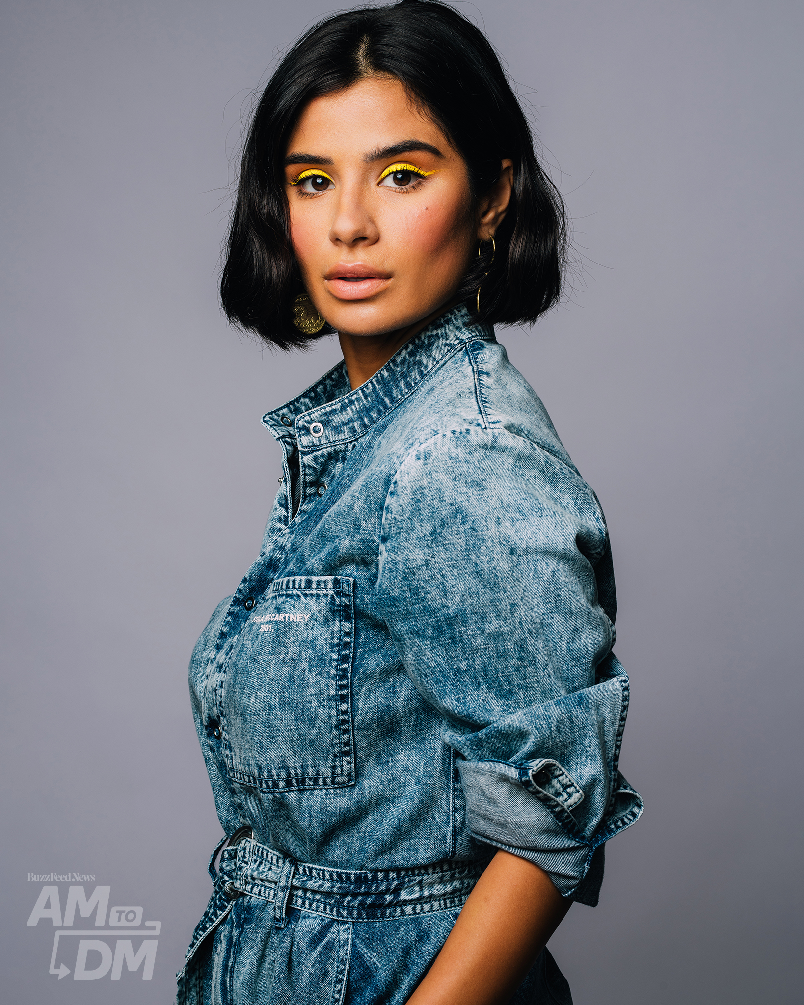 Portrait of Diane Guerrera wearing an acid-wash denim jumpsuit in front of a light gray background. CREDIT: Taylor Miller / BuzzFeed News