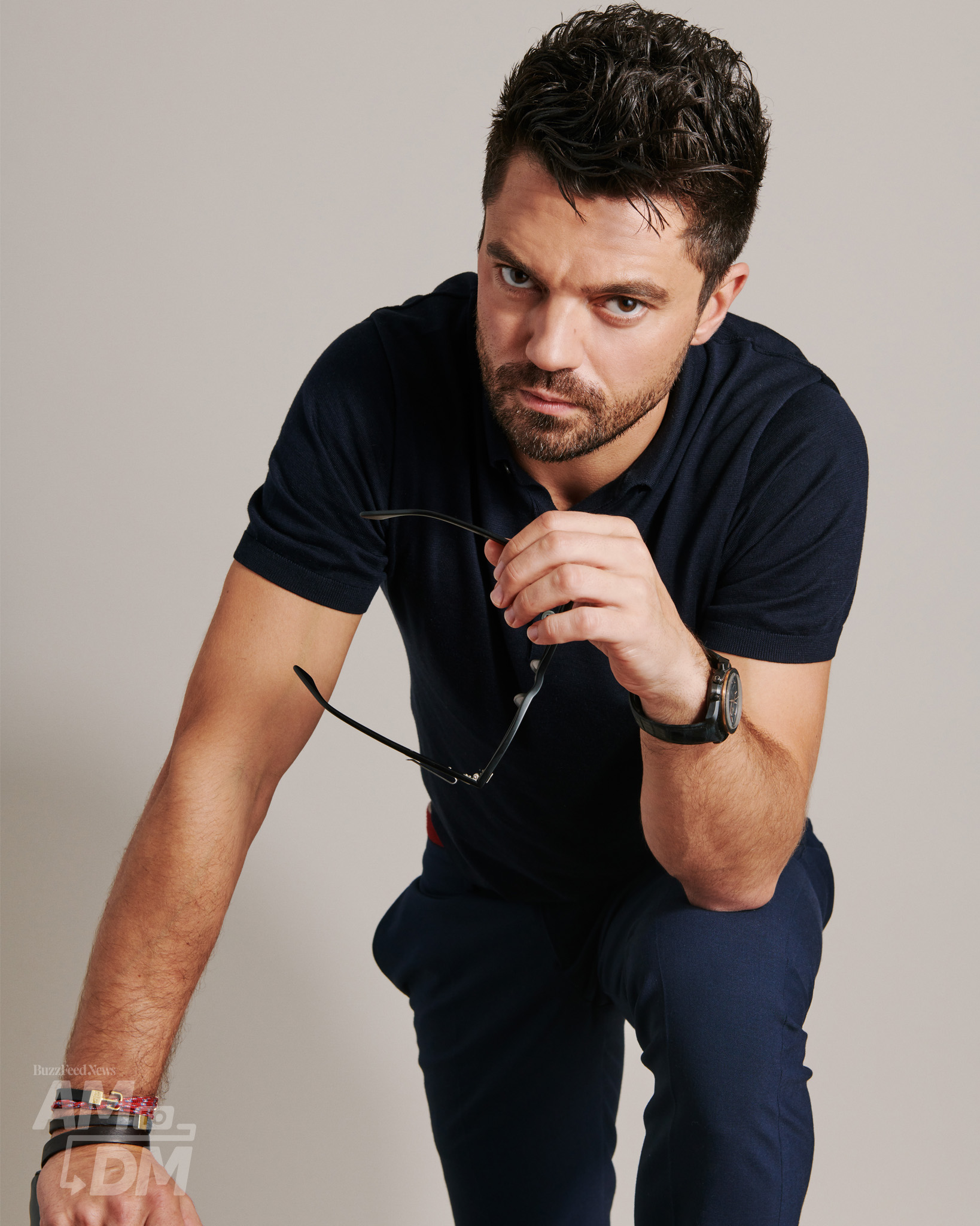 Portrait of Dominic Cooper wearing a black shirt and blue pants in front of a taupe background CREDIT: JJ Reddington / BuzzFeed News