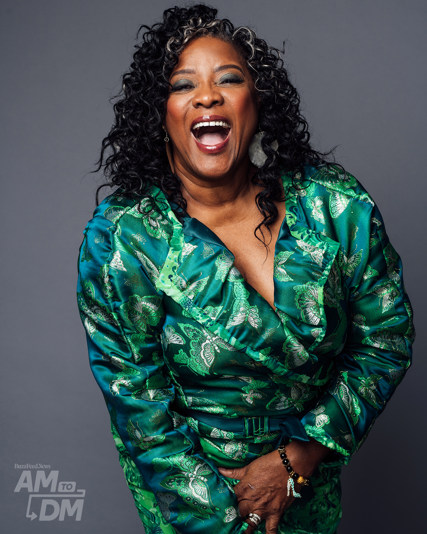 Portrait of Loretta Devine wearing a green satin suit and laughing in front of a gray background CREDIT: Taylor Miller / BuzzFeed News