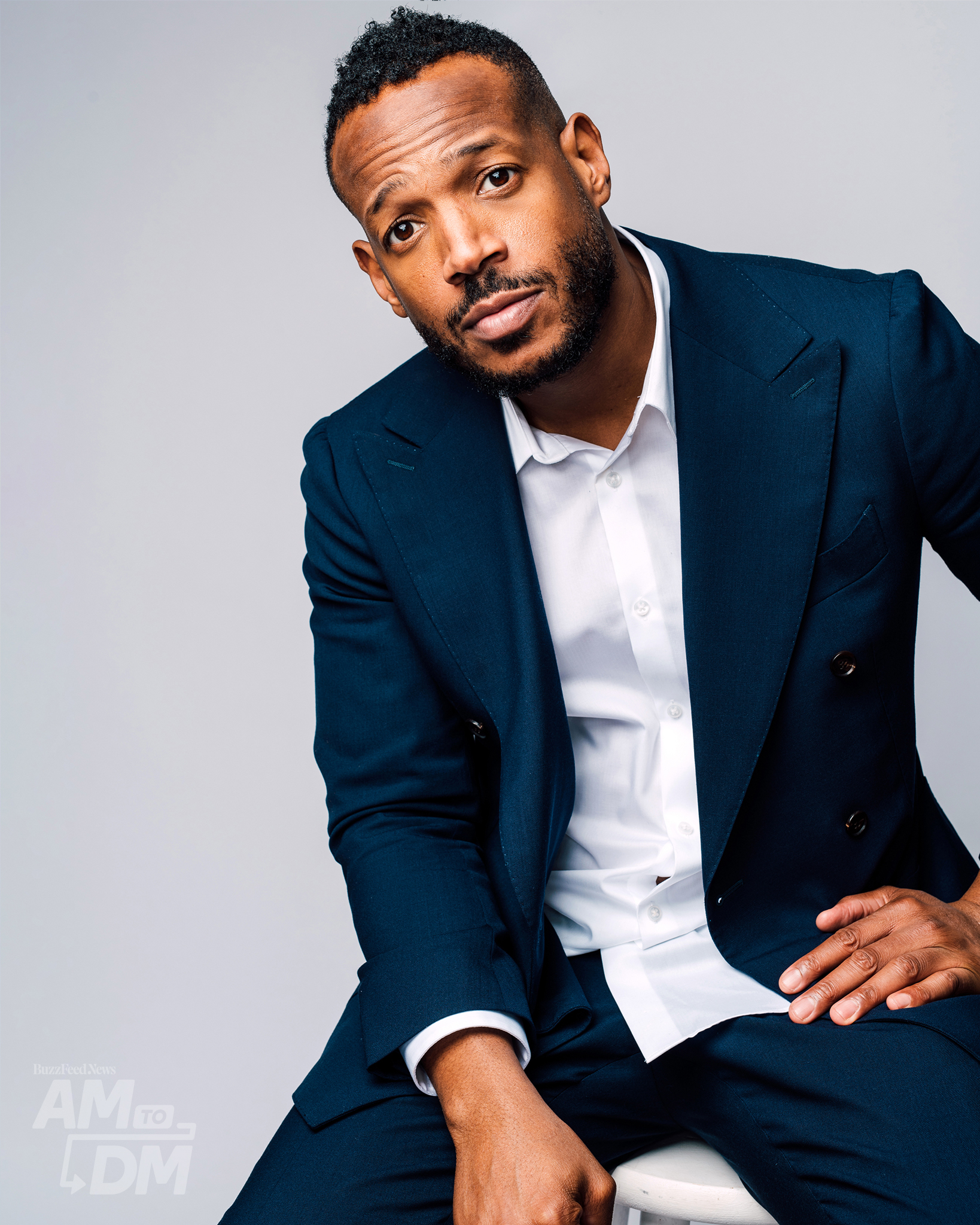 Portrait of Marlon Wayans wearing a blue suit and white shirt in front of a light gray background. CREDIT: Taylor Miller / BuzzFeed News