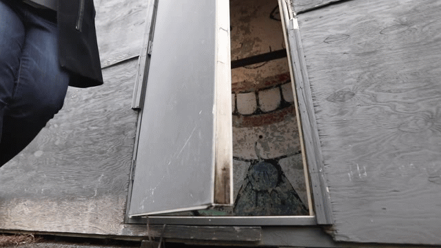 The Tillie cartoon face peeks out from behind a shed door
